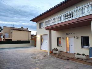 Casa Empordà con piscina exclusiva في Báscara: منزل أبيض مع شرفة وممر