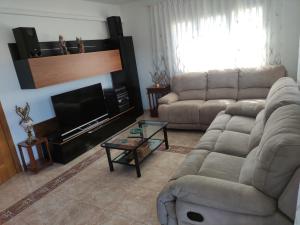 sala de estar con sofá y TV en Casa Empordà con piscina exclusiva, en Báscara