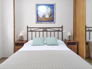 a bedroom with a large bed with two blue pillows at Desconectaengalicia La Lanzada, a pie de playa in A Lanzada