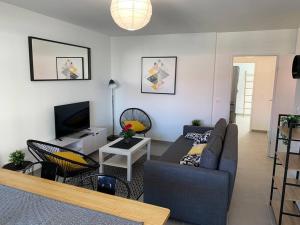 a living room with a couch and a tv at Appart T3 Standing - Terrasse - 2 Parkings in Montpellier
