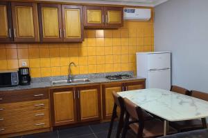 a kitchen with a table and a white refrigerator at Luxurious Studios in Douala