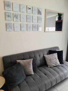un sofá gris con almohadas en la sala de estar en BV ILLIA TERMINAL DE OMNIBUS en Córdoba