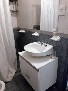 y baño con lavabo blanco y espejo. en BV ILLIA TERMINAL DE OMNIBUS en Córdoba