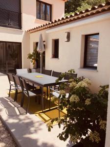 een eettafel en stoelen op een patio bij Villa Francine in Bouc-Bel-Air