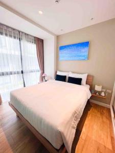 a bedroom with a large white bed and a window at Diamond Resort Phuket Bangtao in Phuket
