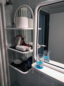 a bathroom shelf with two glasses and a mirror at Ferienwohnung CoCo in Haltern