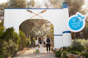 a family walking through an archway with a clock at Travel Hotel Gesher Haziv in Gesher HaZiw