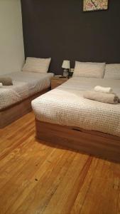 2 camas en una habitación con suelo de madera en Piso san Marcos madrid, en Madrid