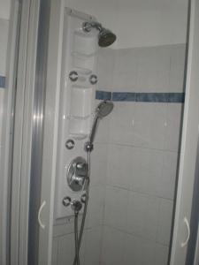 a shower with a shower head in a bathroom at 75 Steps Apartments in Mesongi