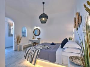 a white bedroom with a bed and a mirror at Ariti Seaside Residence in Naousa