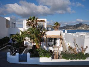Biały dom z palmami nad oceanem w obiekcie Ariti Seaside Residence w mieście Nausa