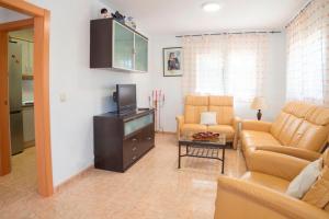 sala de estar con sofá y TV en Club Villamar - Neron en Cubelles