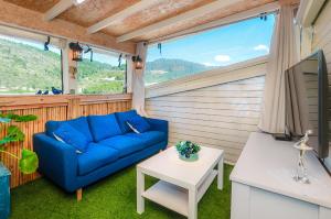 sala de estar con sofá azul y mesa en צימר נוף להר en Shelomi