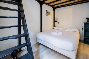 a bedroom with a white bed and a ladder at Beethoven Super emplacement vieille ville in Annecy