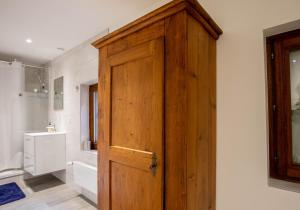 a wooden door in a bathroom with a sink at Beethoven Super emplacement vieille ville in Annecy