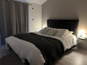 una camera con un grande letto con testiera nera di Appartement chaleureux proche RER/ CDG / Parc Expo a Sevran