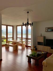 - un salon avec une table et quelques fenêtres dans l'établissement Villa Panoramica, à Lavena Ponte Tresa