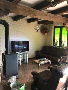 a living room with a couch and a flat screen tv at Dom Nad Jeziorem Łąkorz in Łąkorz