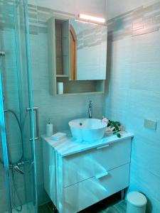 een badkamer met een blauwe wastafel en een douche bij Villa Panoramica in Lavena Ponte Tresa
