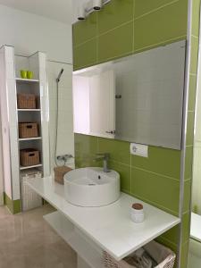 a bathroom with a sink and a mirror at Hoyo 20 de La Monacilla Golf in Huelva