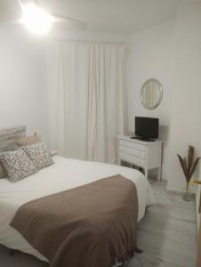 a bedroom with a bed and a desk with a mirror at Zaharaiso luz in Zahara de los Atunes