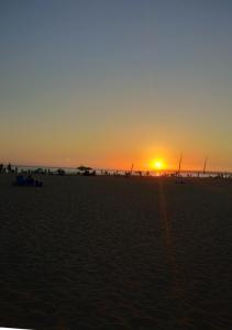 a sunset on a beach with the sun setting at Zaharaiso luz in Zahara de los Atunes