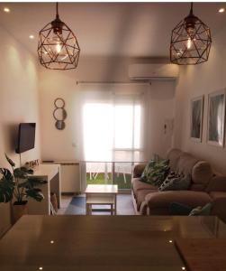 ein Wohnzimmer mit einem Sofa und einem Tisch in der Unterkunft Zaharaiso luz in Zahara de los Atunes