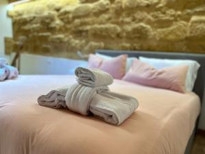 uma pilha de toalhas sentadas em cima de uma cama em LA FORMICA APARTMENT em Agrigento