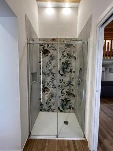 una ducha con puerta de cristal en una habitación en LA FORMICA APARTMENT, en Agrigento