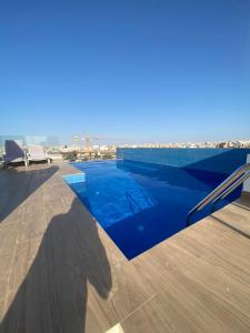 una piscina azul en la azotea de un edificio en Magnifique Appartement avec PISCINE, 3 Chambres, 4 Salles de Bain, Salle de Gym et Terrasse, LUXE ET COMFORT aux ALMADIES, en Dakar