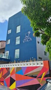 un edificio azul con una pintura a un lado en Porto Vila by AFT, en Porto de Galinhas