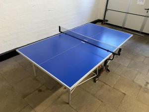 a ping pong table sitting on a tile floor with at FeWo Diekshörn an der Nordsee Elbe am Nord-Ostsee-Kanal in Ramhusen