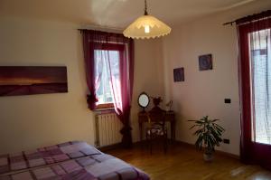 a bedroom with a bed and two windows at Il lago e la collina in Stresa