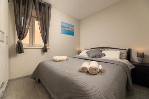 a bedroom with a bed with towels on it at Apartments Neptun in Baška