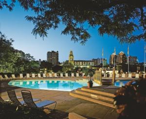 a swimming pool with chairs and a city in the background at InterContinental Kansas City at the Plaza by IHG in Kansas City