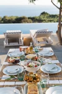 una mesa con platos de comida y copas de vino en Villa Olvía, en Sfakiá