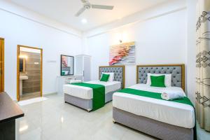 two beds in a white room with a bathroom at Queens mount Ridge in Kandy