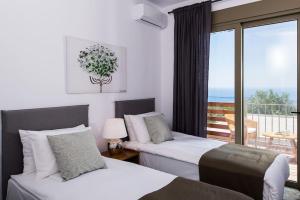 a hotel room with two beds and a balcony at Villa Olvía in Sfakia