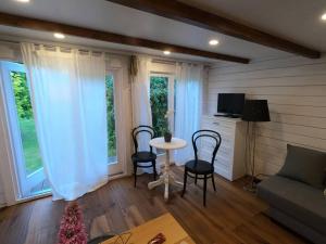 sala de estar con mesa, sillas y ventanas en Gemütliches Tinyhouse im Garten einer Villa, en Bad Sauerbrunn