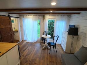 una cocina con mesa y sillas en una casa pequeña en Gemütliches Tinyhouse im Garten einer Villa, en Bad Sauerbrunn