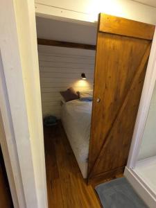a small bedroom with a bed and a wooden door at Gemütliches Tinyhouse im Garten einer Villa in Bad Sauerbrunn