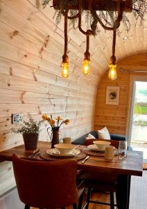 Cette chambre en bois comprend une table avec des chaises et un canapé. dans l'établissement New Farm Cheshire Holidays, à Winsford