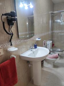 a bathroom with a sink and a toilet and a mirror at Casa La Orilla 1 in Playa Honda