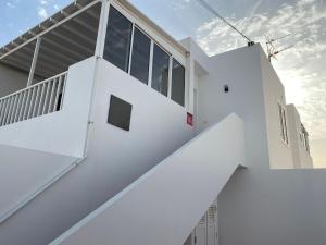 ein weißes Haus mit einer Treppe davor in der Unterkunft Casa La Orilla 1 in Playa Honda