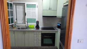 a small kitchen with a sink and a stove at Casa La Orilla 1 in Playa Honda