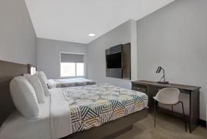1 Schlafzimmer mit einem Bett und einem Schreibtisch sowie einem Bett der Marke sidx sidx sidx. in der Unterkunft Motel 6-Monahans, TX in Monahans