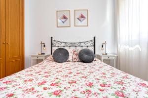 - une chambre avec un grand lit fleuri dans l'établissement Araucaria Garden & Parking, à Malaga