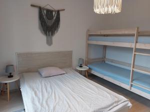a bedroom with two bunk beds and two tables at Mikolajek Nadmorski in Dębki