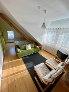 uma sala de estar com um sofá verde e uma televisão em Penzion Viktoria em Znojmo