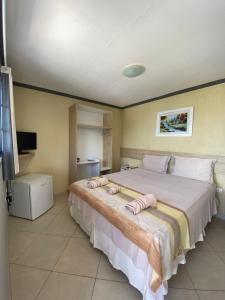 um quarto com uma cama grande com duas toalhas em Pousada Pérola do Mar em Tamandaré